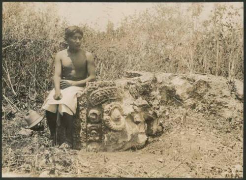 Boy with Tlaloc carved altar in milpa