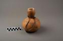 Gourd container, small, with incised design, leather strap tied around neck