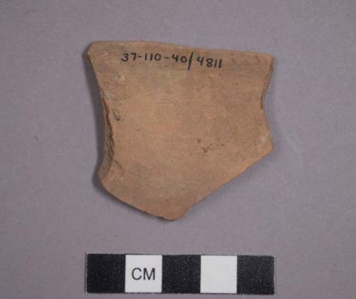 Apparently a pottery sauceboat fragment with small adhering traces of grey-blue