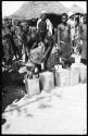 Women pouring grain from sack into tins