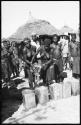 Women pouring grain from sack into tins