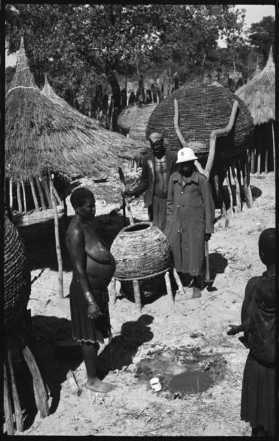 People standing near grain storage baskets