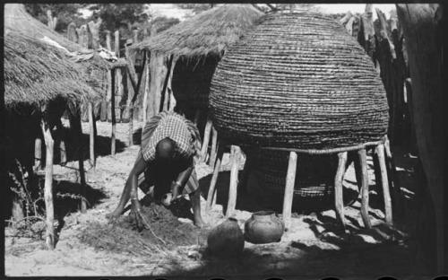 Woman working and leaning over, with storage basket behind her