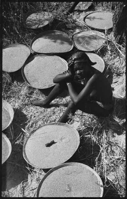 Woman sitting next to baskets of grain