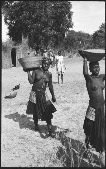 Two women carrying baskets