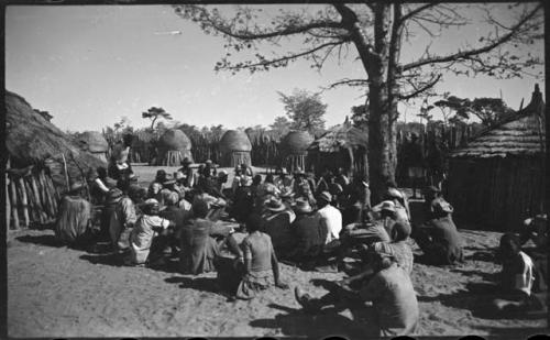 Group of people sitting, with storage baskets in background