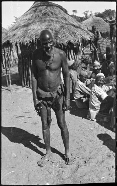 Man standing next to a group of people sitting