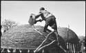 Man pouring grain from a can into a storage basket