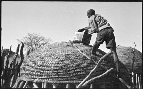 Man pouring grain from a can into a storage basket