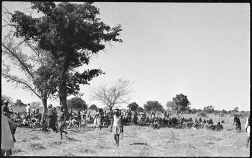 People walking in front of a large group of people sitting