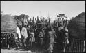 Group of people standing near storage baskets and kraal fence