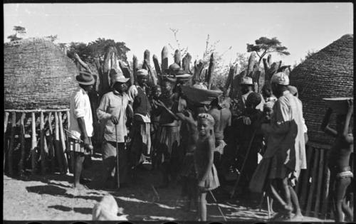 Group of people standing near storage baskets and kraal fence