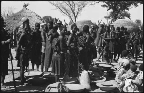 Women standing near sacks and baskets of grain