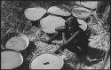 Woman sitting next to baskets of grain