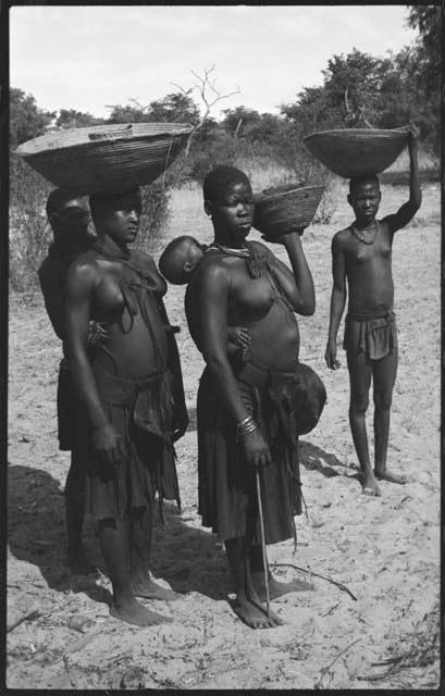 Women carrying baskets on their heads and babies on their backs