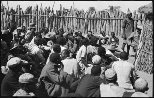 Group of men sitting inside kraal