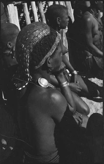 Woman sitting with a group, close-up showing her hairstyle