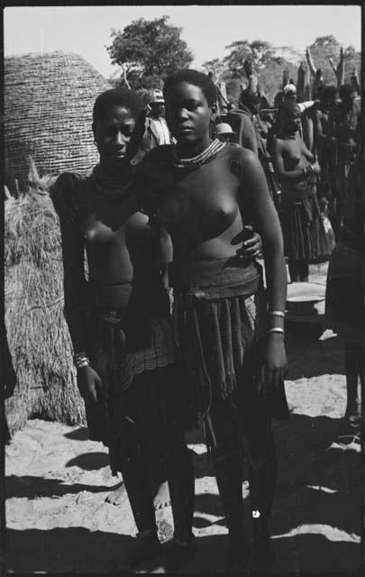 Two women standing, with their arms around each other