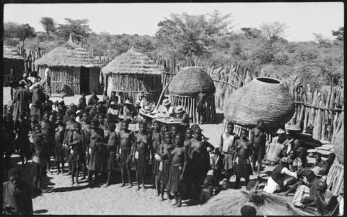 Group of women standing in front of government officials collecting grain tax