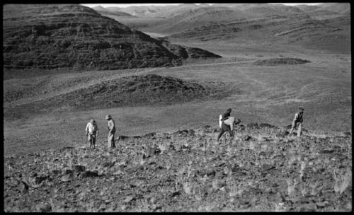 Five men climbing a hill