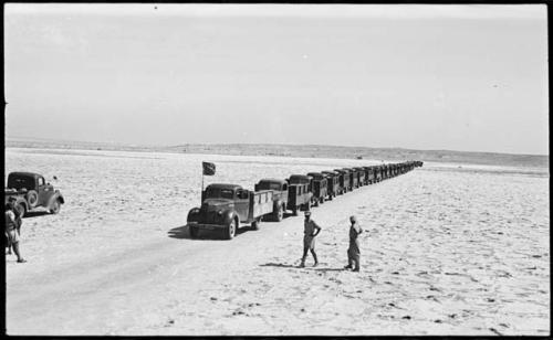 People walking in front of trucks waiting to be loaded with salt