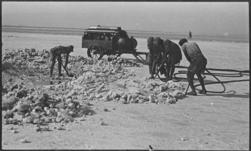 Men breaking up pieces of salt