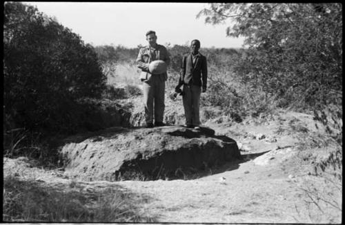 Two men standing on the Hoba meteorite