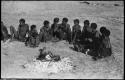 Group of people sitting next to a fire