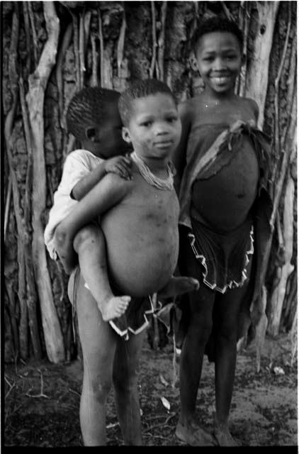 Two girls, one carrying a baby