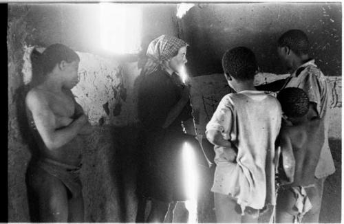 Children and Elizabeth Marshall Thomas in Okwa hut with wall drawings