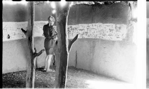 Elizabeth Marshall Thomas standing in the hut with wall drawings