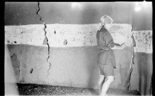 Elizabeth Marshall Thomas standing in the hut with wall drawings