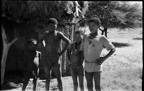 Boys standing beside the Okwa hut with wall drawings