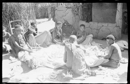 People husking corn in Okwa house courtyard