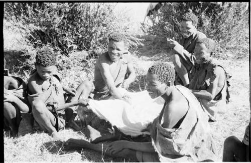 5 men working on an animal skin