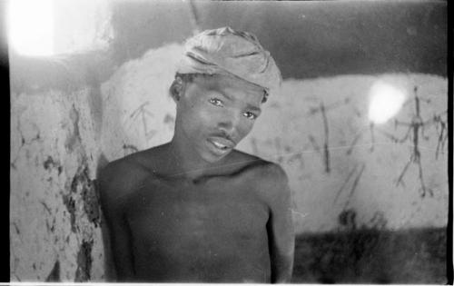 Boy in the Okwa hut with wall drawings