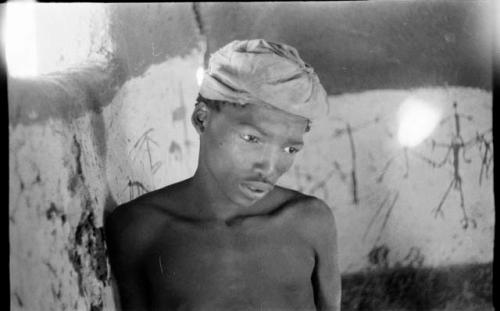 Boy in the Okwa hut with the wall drawings