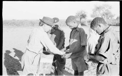 Group of men hulling corn