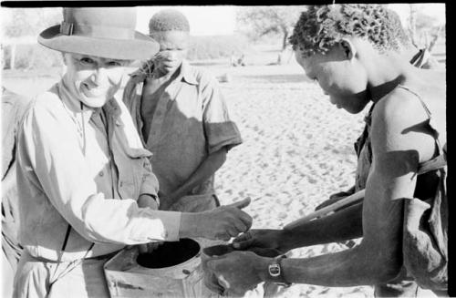 Group of men receiving food from Lorna Marshall