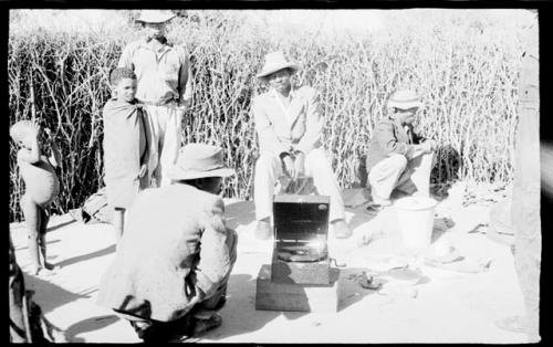 Boys, Chuana, and four other people listening to Boys' phonograph