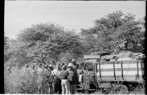 Elizabeth Marshall Thomas and Laurence Marshall talking by the truck with group of people behind them