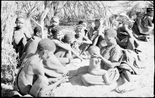 Mother with her child in her lap sitting with a group of people