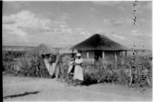 Woman standing in front of a hut