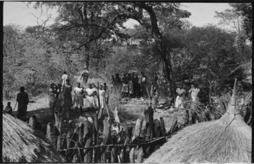 Group of people, mostly women, standing outside the fence