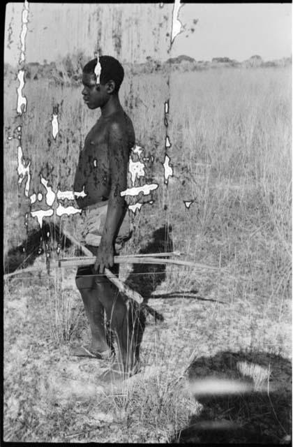 Man standing and holding a bow and arrows