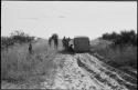 Men standing next to a truck stopped in the sand