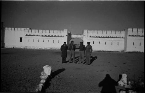 Four men standing in front of Fort Namutoni