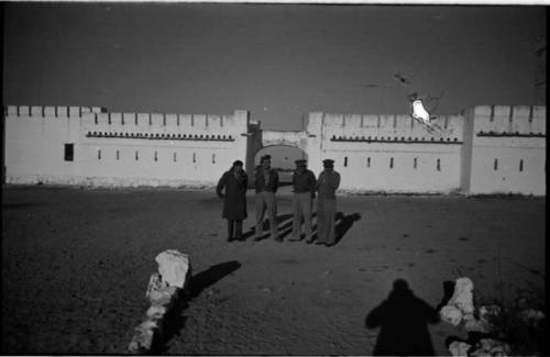 Four men standing in front of Fort Namutoni