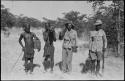 Four men standing and holding guns and cases