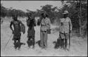 Four men standing and holding guns and cases